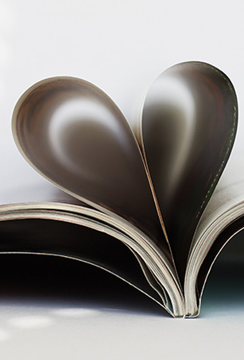 Seiten eines aufgeschlagenen Buches sind zu einer Herzform gebogen