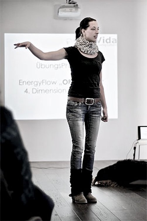 Frau hält einen Vortrag vor einer Leinwand